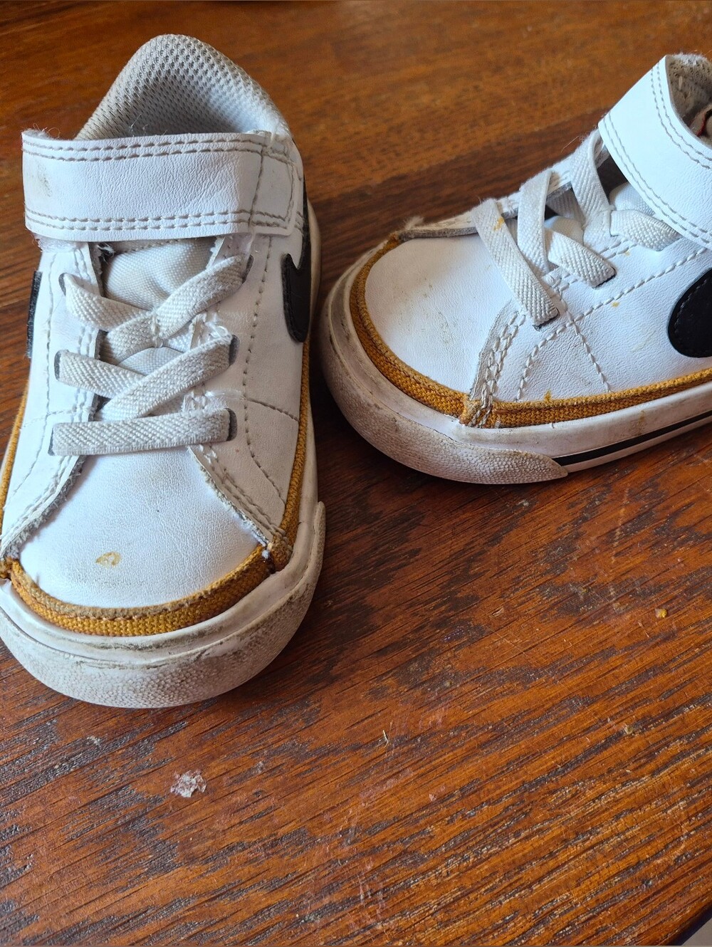 White Nike Kids Sneakers with Black Accent and Gold Trim